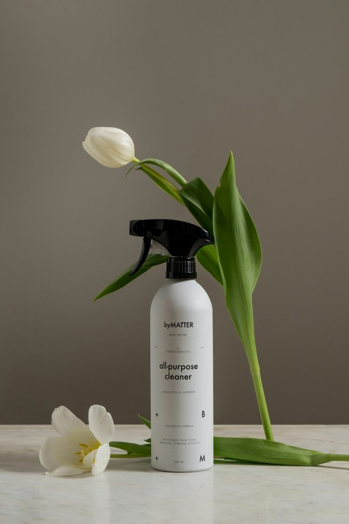 a-bottle-of-deodorant-next-to-a-flower-bm3nfgcecse